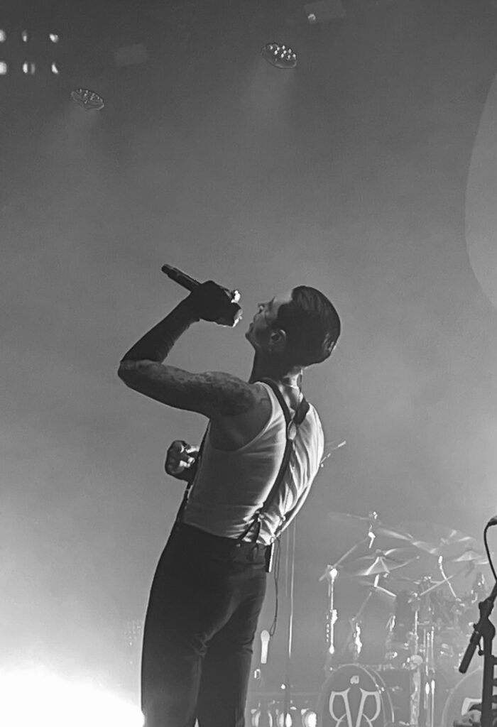 Black-and-white side view of a vocalist singing into a microphone