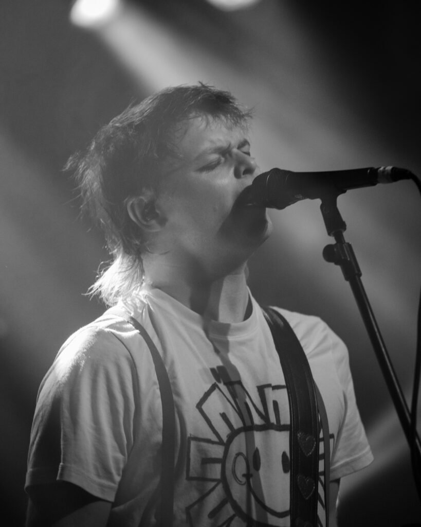 Black-and-white close-up of a vocalist singing into a microphone