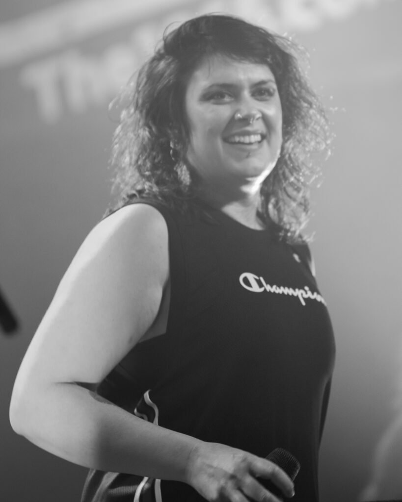 Black-and-white photograph of a smiling performer on stage